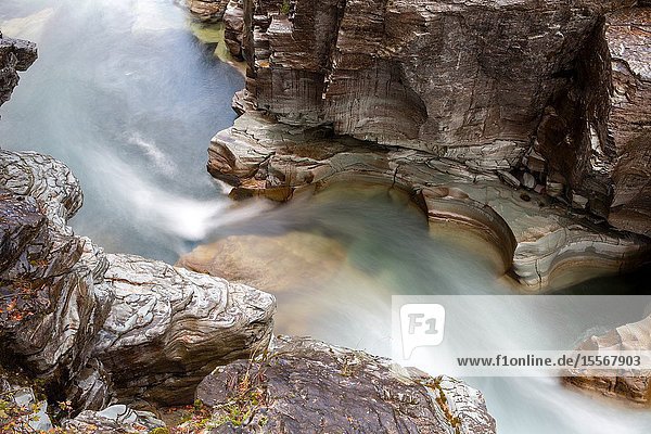 Water surges through a narrow rock canyon in Glacier National Park.