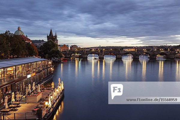 Evening on Vltava river in Prague Czechia. Charles Bridge in the distance.