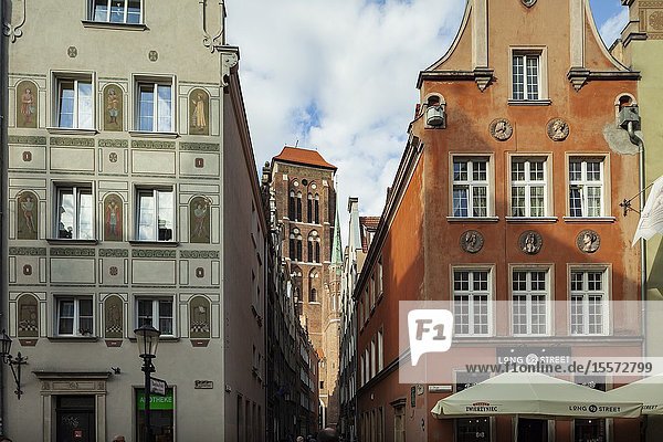 Narrow street in Gdansk old town Poland. St Mary's basilica tower in the distance.
