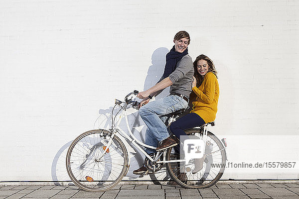 Germany  Bavaria  Munich  Young couple on bicycle  smiling