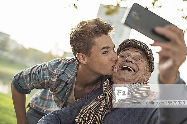 Glücklicher älterer Mann  der mit seinem Enkel ein Selfie macht