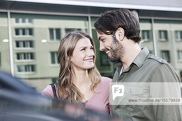 Deutschland  Köln  Junges Paar beim Auto  lächelnd