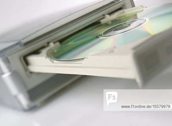 Nahaufnahme einer CD-Rom im CD-Laufwerk vor weißem Hintergrund