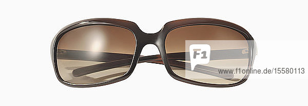 Braune Sonnenbrille vor weißem Hintergrund  Nahaufnahme