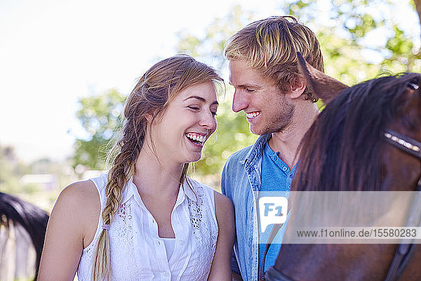 Glückliches junges Paar mit Pferd