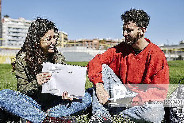 Zwei unglückliche Schüler sitzen im Park und lernen zusammen