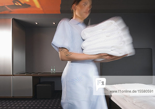 Deutschland  Zimmermädchen mit Handtüchern in einem Hotelzimmer