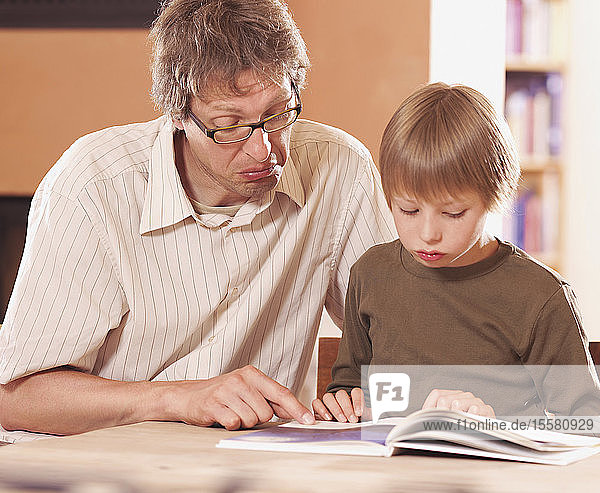 Vater und Sohn lesen Buch