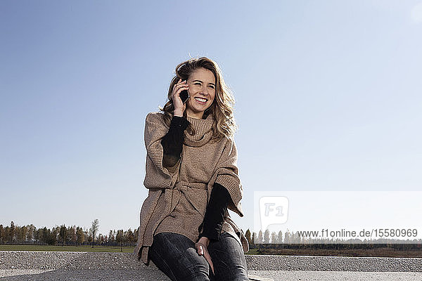 Germany Bavaria Munich Young woman on cell phone smiling