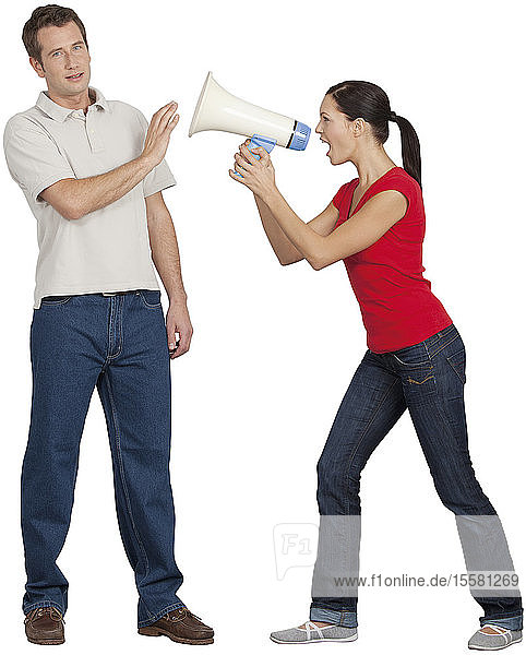 Young woman with megaphone shouting on mid adult man