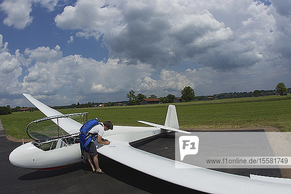 Deutschland  Bayern  Bad Tölz  Reifer Mann bereitet Segelflugzeug vor