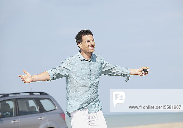 Deutschland  Mann mit Auto am Strand  lächelnd