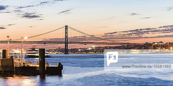 25. April Brücke über den Tejo von Cacilhas aus gesehen bei Sonnenuntergang  Lissabon  Portugal