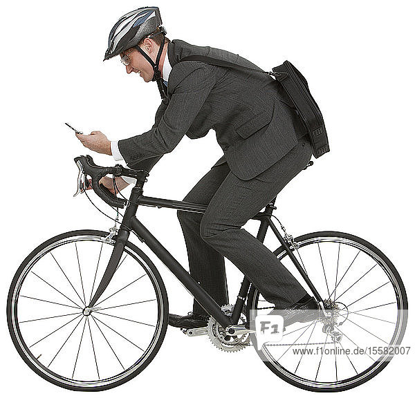 Businessman riding bicycle and using mobile phone