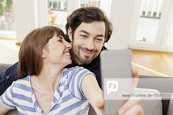 Happy couple taking selfie at home