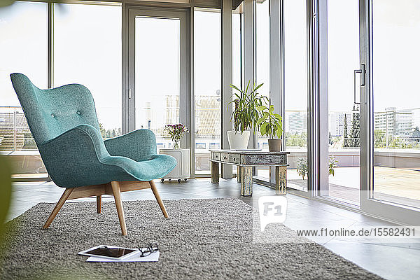 Home interior with armchair tablet and view on roof terrace