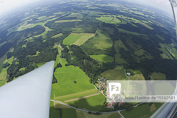 Deutschland  Bayern  Bad Tölz  Blick auf Dorf und Landschaft aus dem Segelflugzeug