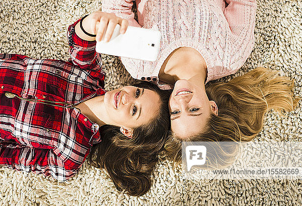 Zwei Freundinnen beim Selfie mit Smartphone zu Hause