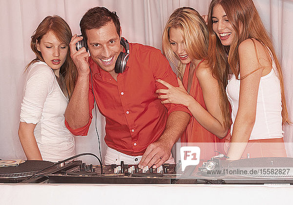 Deutschland  Stuttgart  DJ-Mann umgeben von drei Frauen in einem Nachtclub