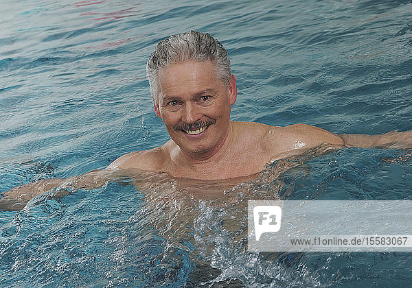 Deutschland  Nürnberg  Senior Mann im Schwimmbad  Porträt  lächelnd