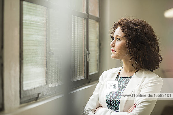 Young businesswoman looking out of window