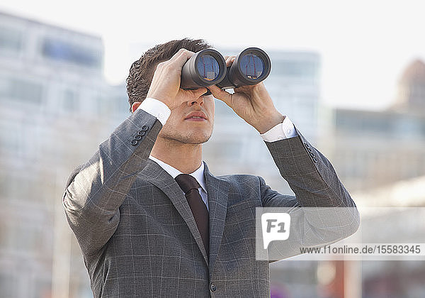 Germany  Young man looking through binocular
