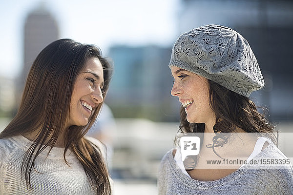 Zwei lächelnde Freundinnen kommunizieren