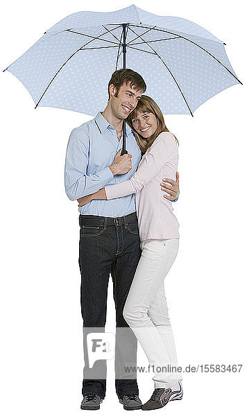 Paar umarmt sich unter einem Schirm  lächelnd