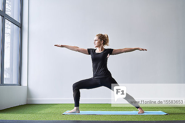 Frau macht Yoga-Übung im Studio