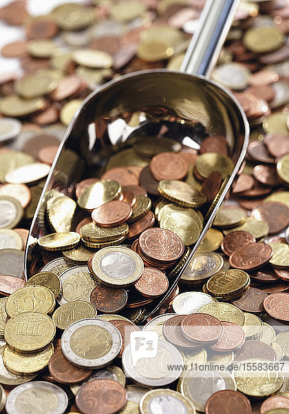 Nahaufnahme einer Vielzahl von Euro-Münzen mit Schaufel