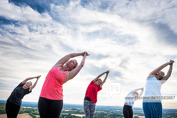 Gruppe von Frauen  die an einer Yogastunde an einem Berghang teilnahmen.