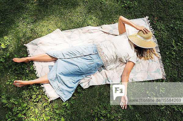 Woman lying on blanket in park