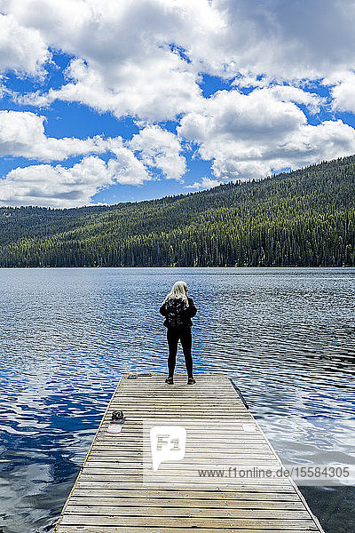 Woman standing on jetty on lake in Stanley  Idaho  USA