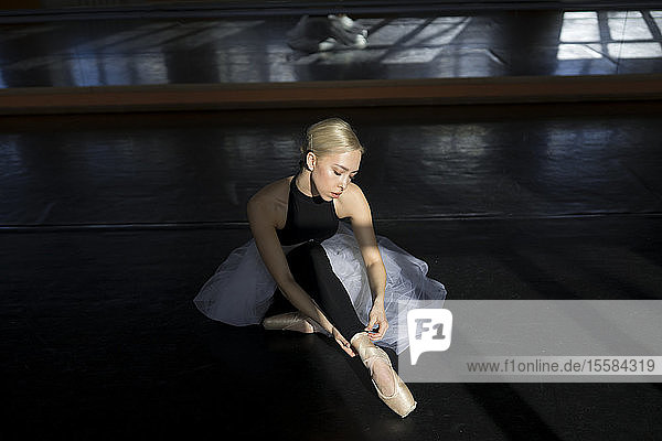 Balletttänzerin passt Leggings im Studio an