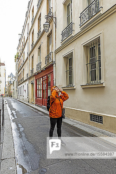 Frau mit Regenmantel auf der Straße in Paris  Frankreich