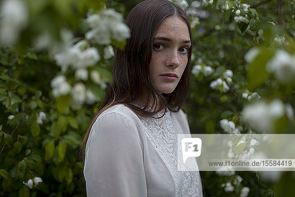 Junge Frau zwischen weißen Blüten