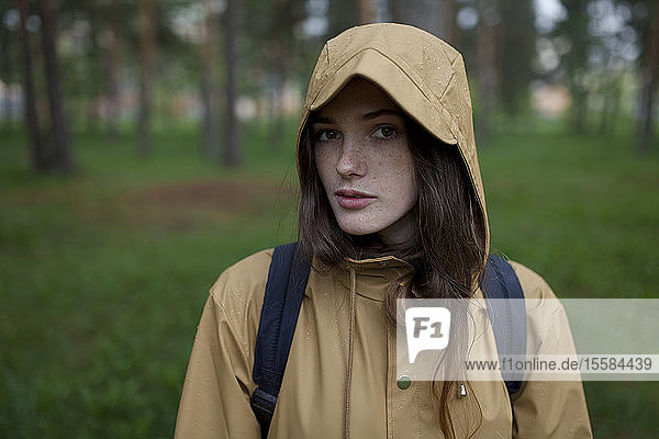 Porträt einer jungen Frau mit braunem Regenmantel