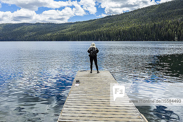 Woman standing on jetty on lake in Stanley  Idaho  USA