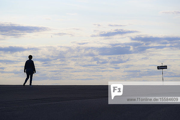 Silhouette of woman walking at sunset