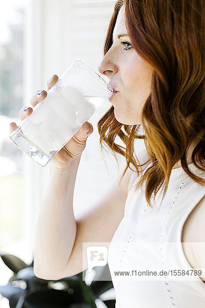 Mittlere erwachsene Frau trinkt Wasser