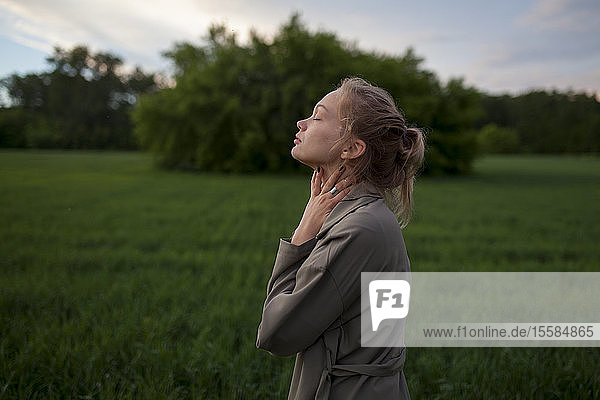 Junge Frau mit geschlossenen Augen in einem Feld