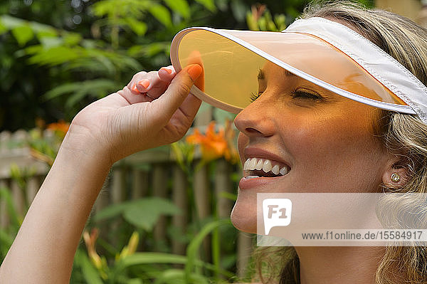 Smiling young woman wearing orange visor