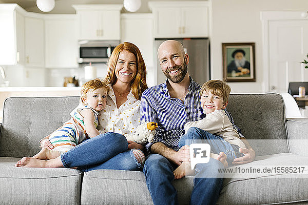 Family smiling on sofa