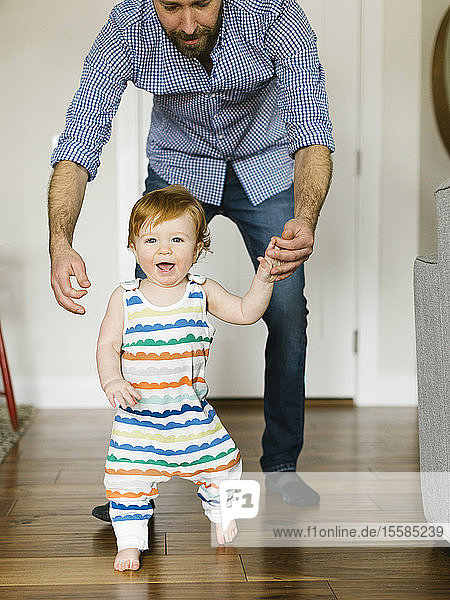 Father helping baby boy to walk