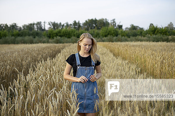 Young woman wearing overall dress in wheat field