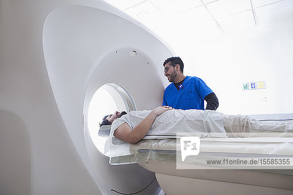 Junger männlicher Radiologe am CT-Scanner in der radiologischen Abteilung