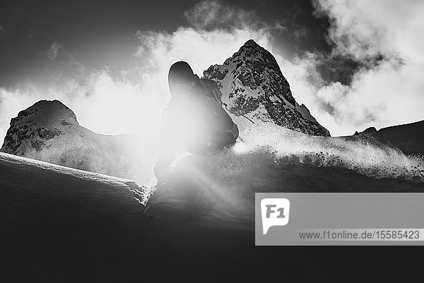 Silhouettenskiläufer beim Skifahren auf einem sonnenbeschienenen Berg schwarz-weiß Squamish Britisch-Kolumbien Kanada