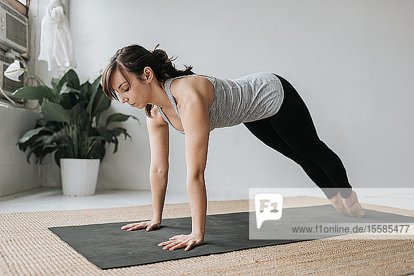 Frau praktiziert Yoga im Studio