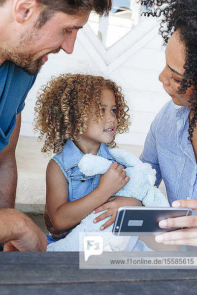 E-Learning für Paare mit Tochter auf Smartphone im Strandhaus