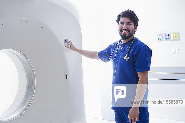 Junger männlicher Radiologe am CT-Scanner in der radiologischen Abteilung  Portrait